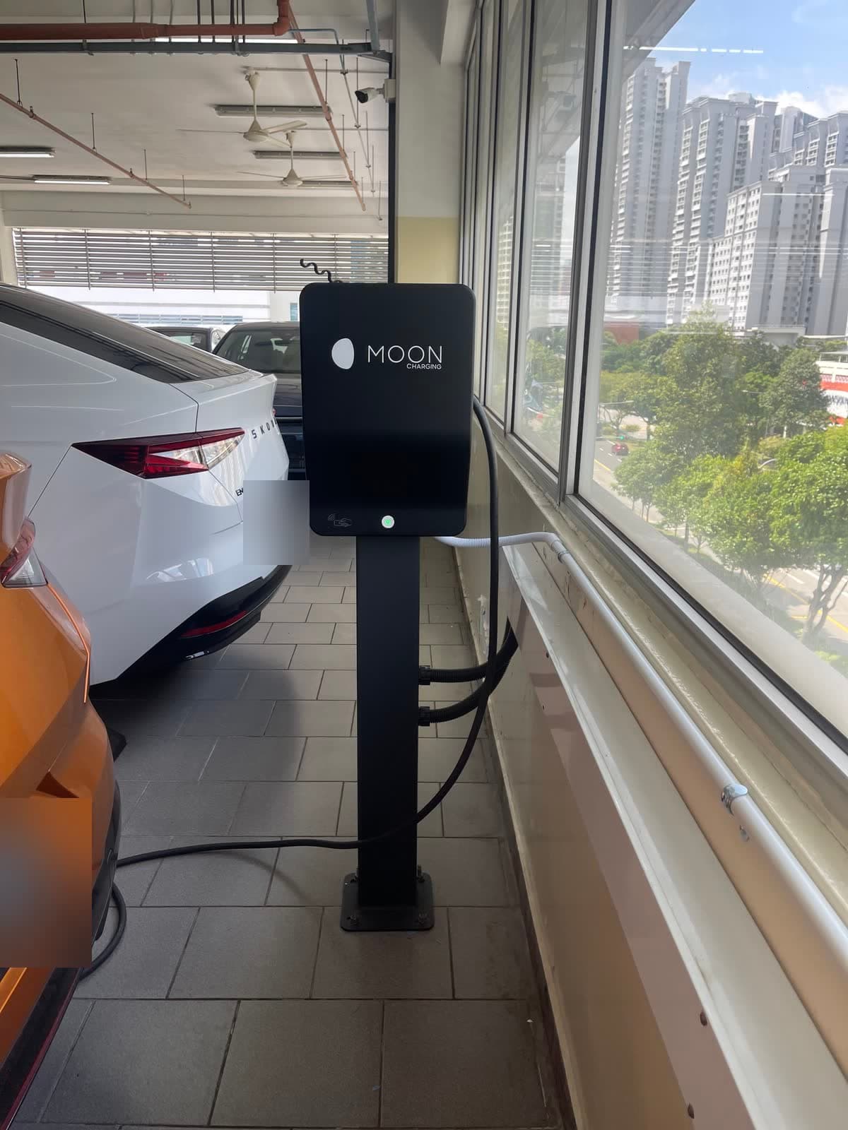 Pedestal AC charger between EV parking bays in a multi-storey car park