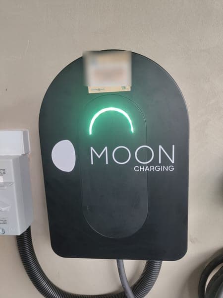 Close-up of a Moon Charging wallbox with a green status light