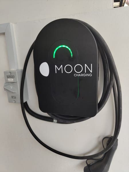 Moon Charging wallbox with a green light and a long coiled cable