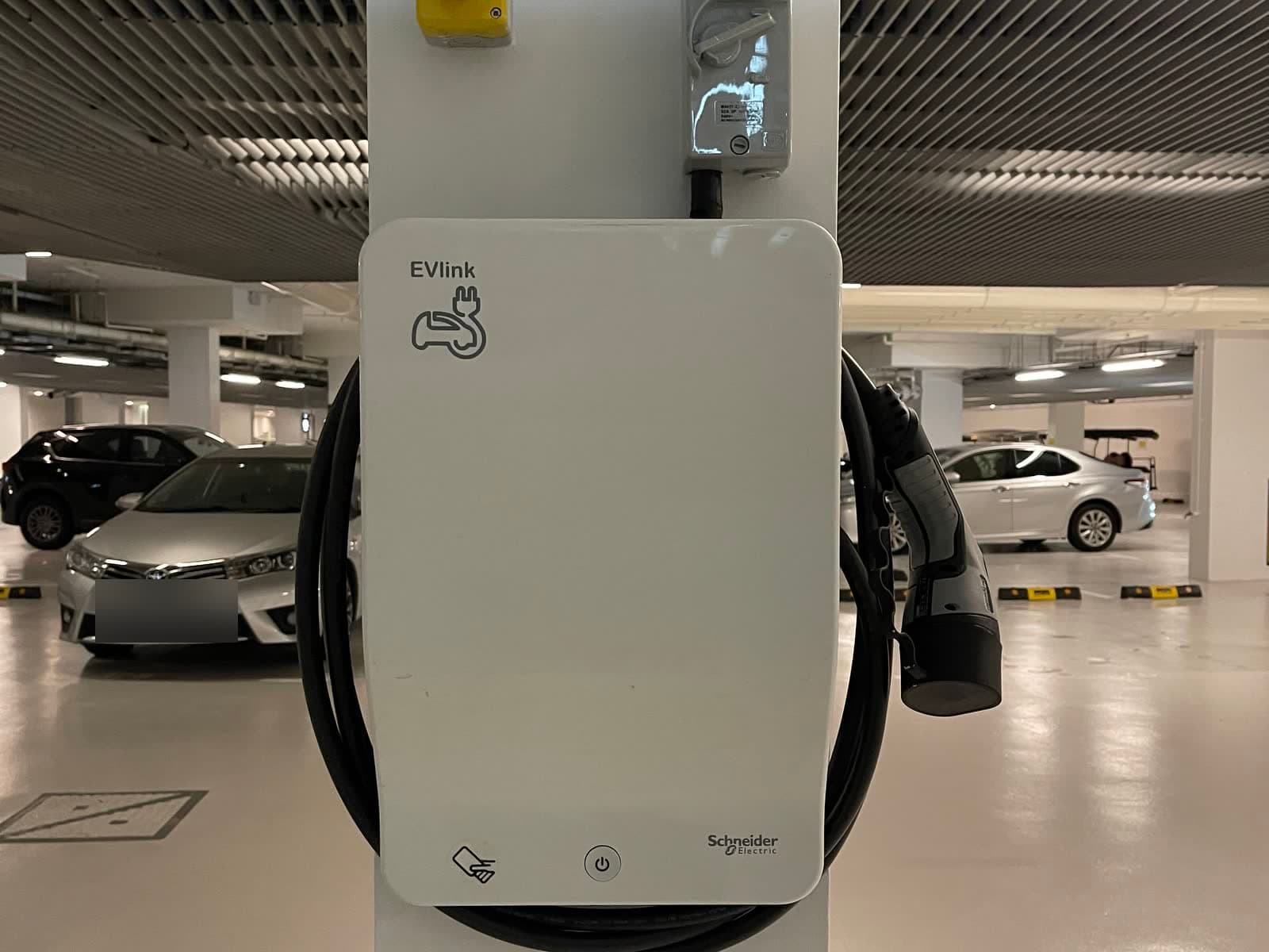 Schneider EVlink wall charger with its isolator on a pillar in the basement car park at The Coast @ Sentosa Cove