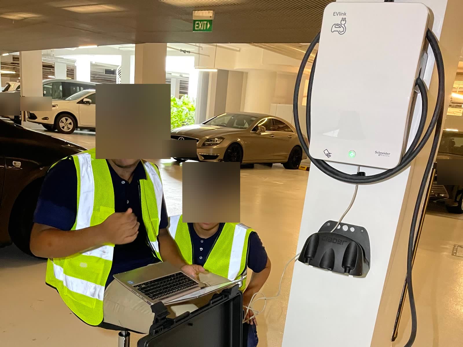 SuperCharge.SG technicians in safety vests running an inspection on a shared EV charger at The Coast @ Sentosa Cove