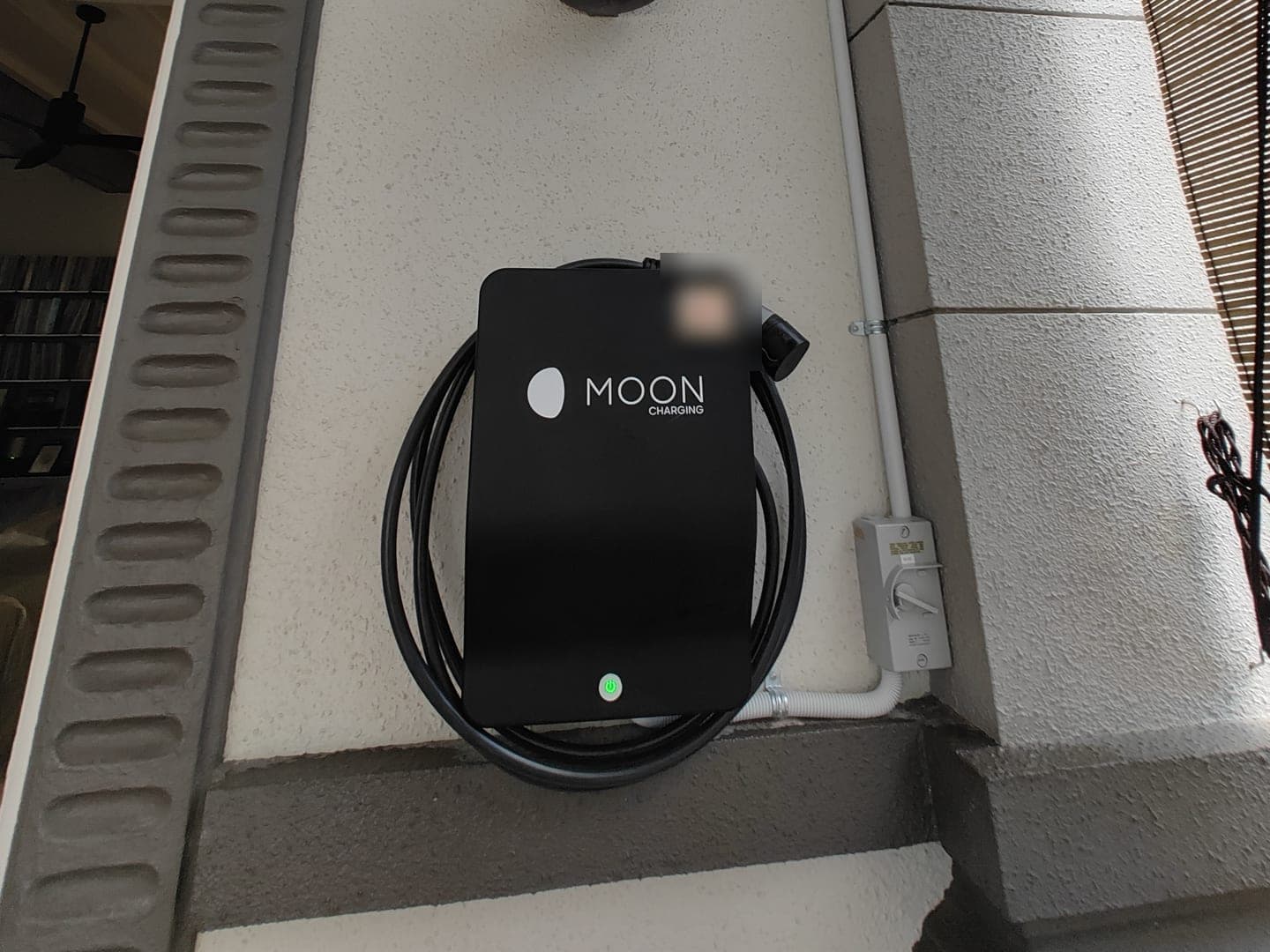 Moon Charging wallbox and isolator mounted on the porch wall of a landed home