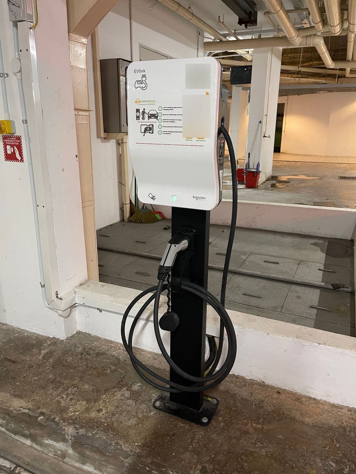 Schneider EVlink charger on a black pedestal with its Type 2 cable coiled on the post, in the car park at The Madeira