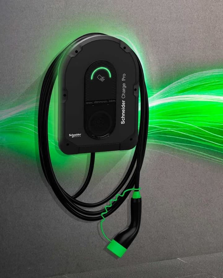 Schneider Charge Pro wallbox with a green status ring and coiled cable on a grey wall